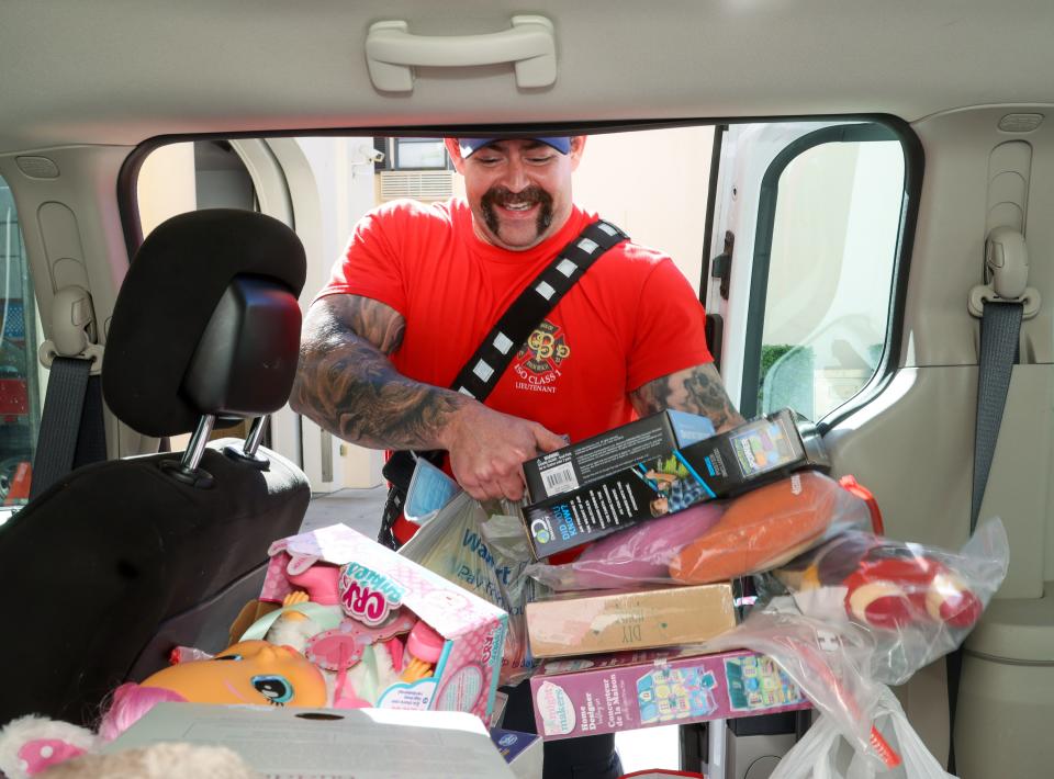Palm Beach firefighter Jerry Castillo helps to carry toys out of Fire-Rescue Station No. 1 that were collected in December for the annual Town of Palm Beach United Way Toy Drive. The United Way plans to hold a Nov. 26 toy drive reception.