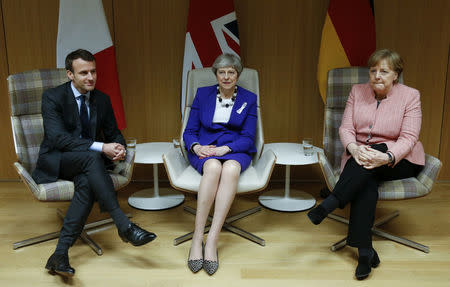 Britain's Prime Minister Theresa May is flanked by French President Emmanuel Macron and German Chancellor Angela Merkel before their trilateral meeting at the European Union leaders summit in Brussels, Belgium. REUTERS/Francois Lenoir