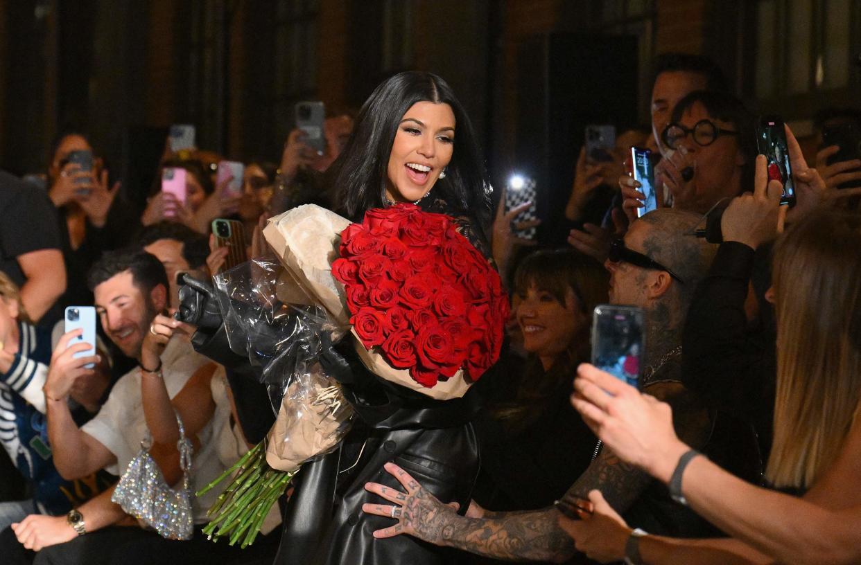 Kourtney Kardashian receives roses from her husband Travis Barker at the Boohoo by Kourtney Kardashian show during New York Fashion Week on Sept. 13, 2022.