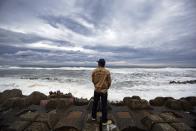 A man watches waves break into anti-tsunami barriers after a storm in Iwaki, Fukushima Prefecture September 16, 2013. Tokyo Electric Power Co (TEPCO), operator of the tsunami-crippled Fukushima Daiichi nuclear power plant, said on Monday it released what was believed to be untainted rainwater around the storage tank areas into the ocean in order to avoid flooding near the tanks due to heavy rains by Typhoon Man-yi, local media reported. REUTERS/Stringer