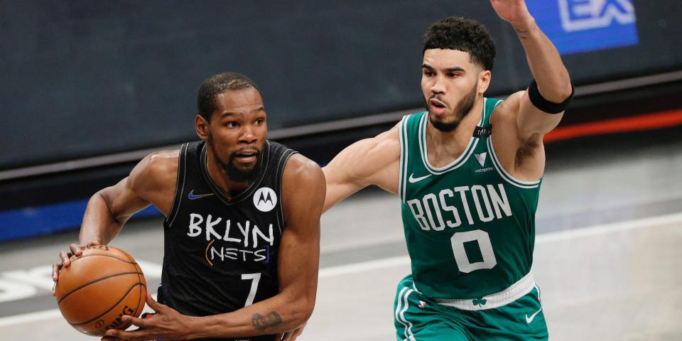 Kevin Durant drives past Jayson Tatum during a game.