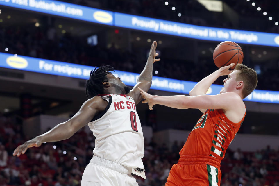 North Carolina State forward D.J. Funderburk (0) defends while Miami forward Sam Waardenburg (21) shoots during the second half of an NCAA college basketball game in Raleigh, N.C., Wednesday, Jan. 15, 2020. (AP Photo/Gerry Broome)