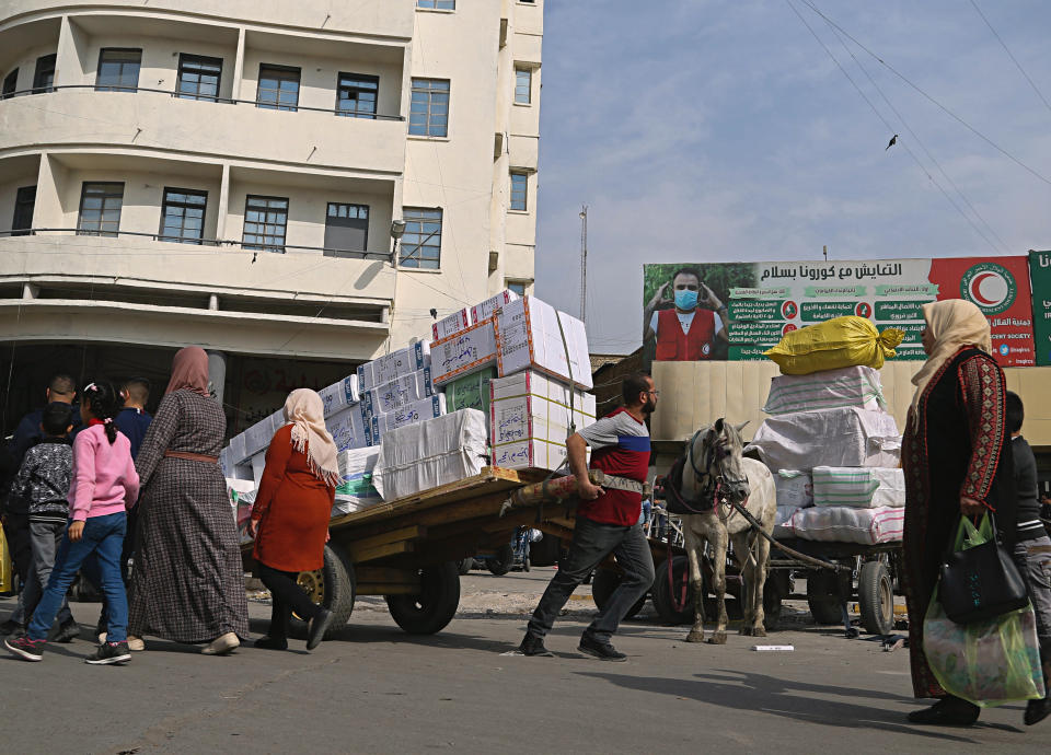 A worker pulls a cart in the Shorja market of Baghdad, Iraq, Sunday, Feb. 20, 2022. (AP Photo/Hadi Mizban)