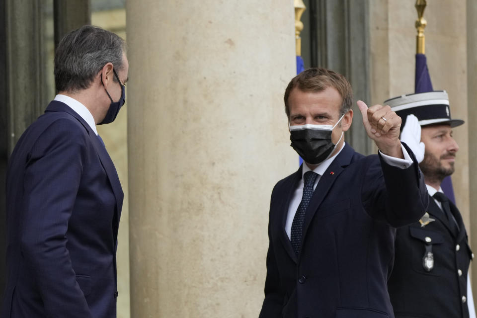 French President Emmanuel Macron, right, thumbs up as he welcomes Prime Minister Kyriakos Mitsotakis Tuesday, Sept. 28, 2021 at the Elysee Palace in Paris. The leaders of Greece and France are expected to announce a major, multibillion-euro deal in Paris on Tuesday involving the acquisition by Greece of at least six French-built warships, Greek state ERT TV reported. (AP Photo/Francois Mori)