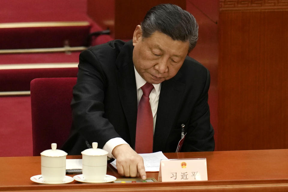 Chinese President Xi Jinping presses a button to vote on work reports during the closing session of the National People's Congress held at the Great Hall of the People in Beijing, Monday, March 11, 2024. (AP Photo/Ng Han Guan)