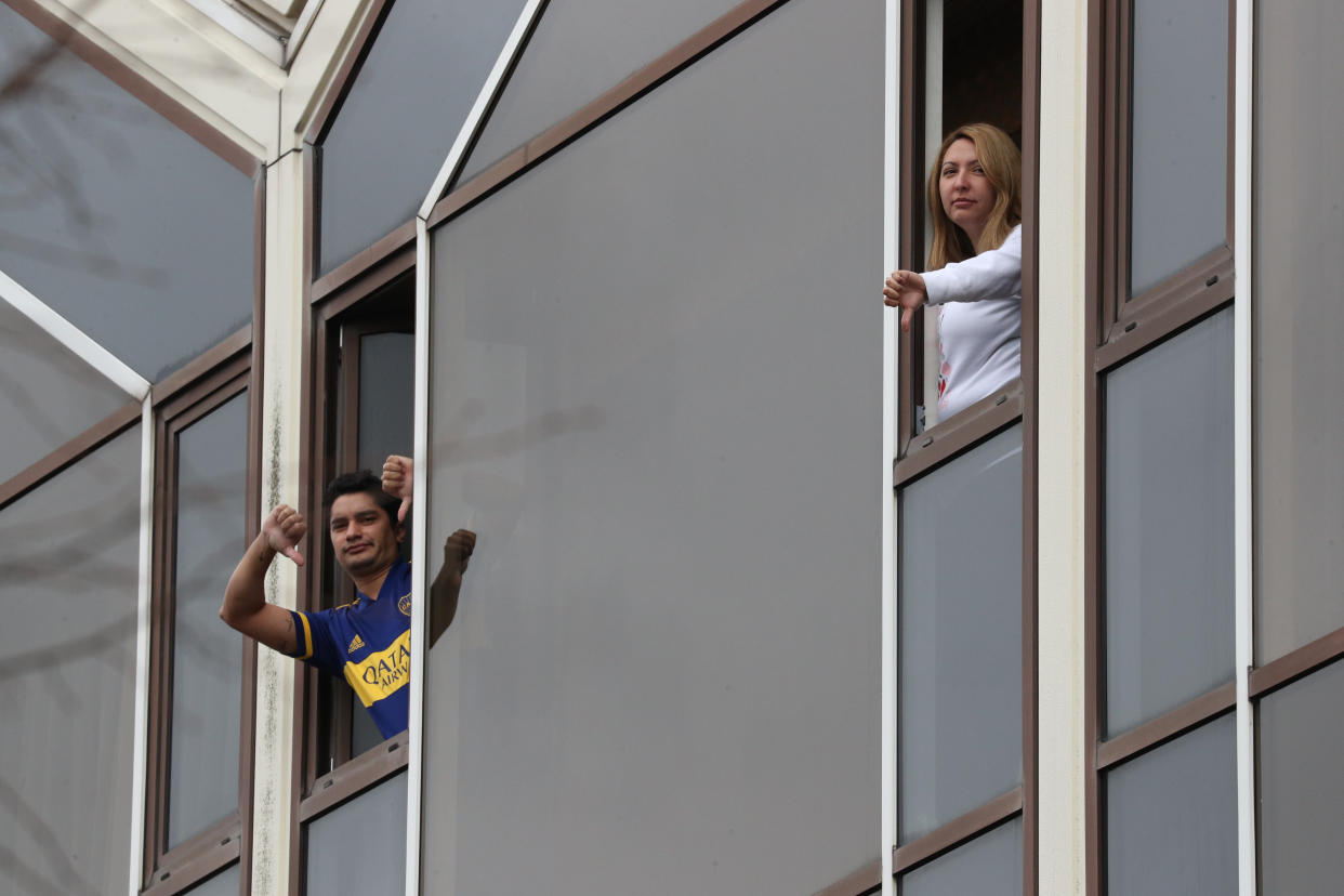 Two quarantined travellers in the same room making a thumbs down gesture out of their windows in the Radisson Blu Edwardian hotel, near Heathrow Airport, London, a Government-designated quarantine hotel being used for travellers to stay during a 10-day quarantine after returning to England from one of 33 