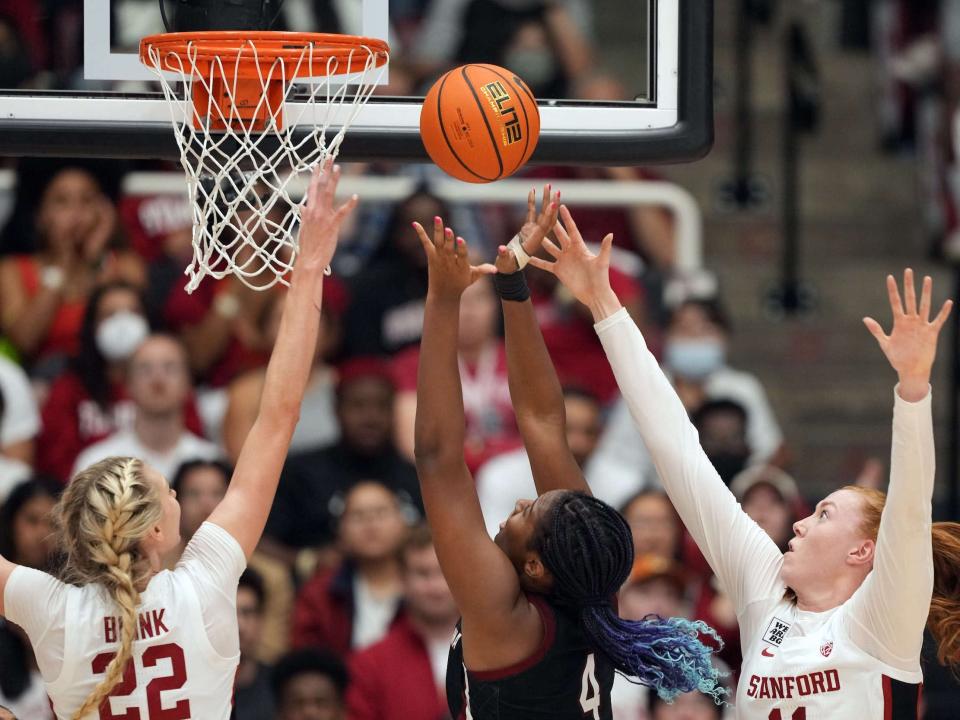 Aliyah Boston (center) shoots around two Stanford Cardinal defenders.