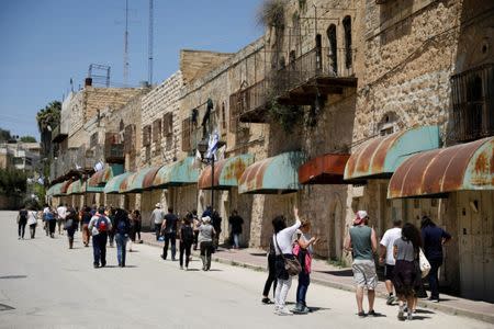 FILE PHOTO: Visitors on a tour held by leftwing NGO "Breaking the Silence" walk down Shuhada street in the West Bank city of Hebron April 19, 2017. REUTERS/Amir Cohen/File Photo