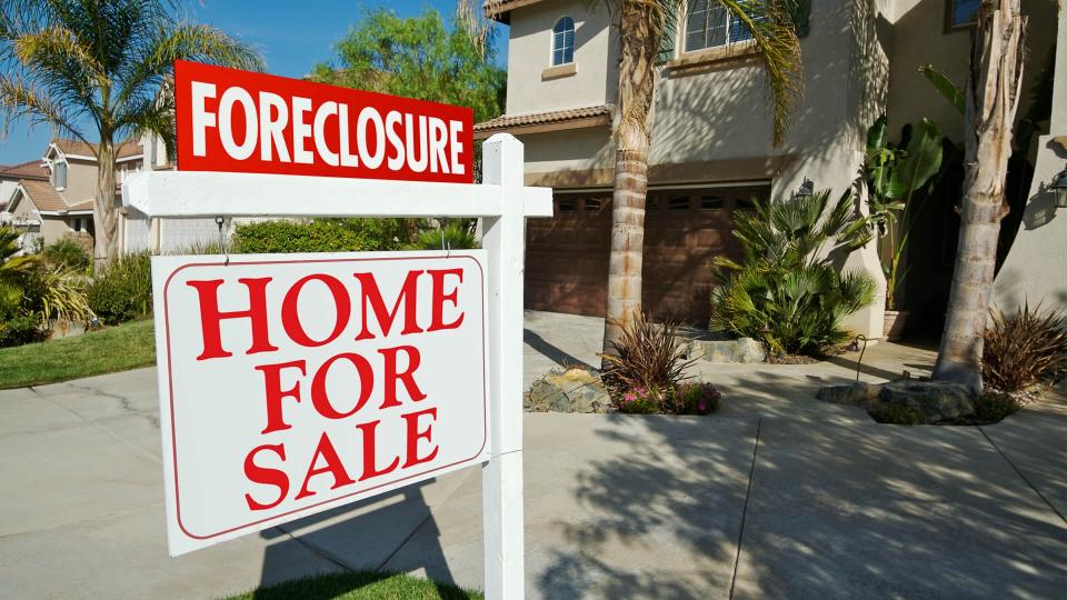 foreclosure sign in front of home for sale