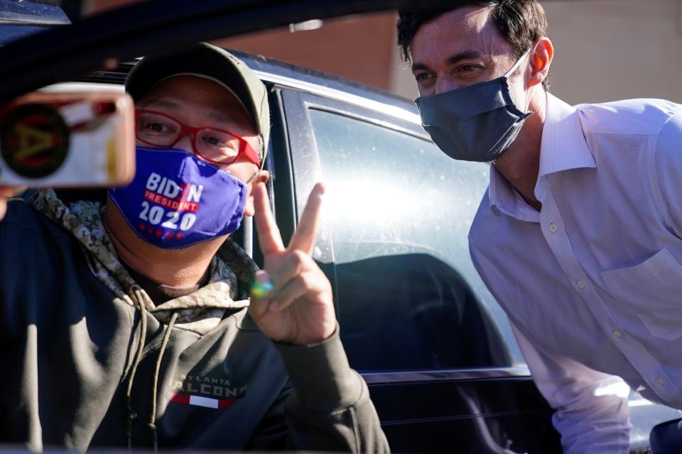 A supporter takes a selfie with Democratic Senate candidate Jon Ossoff during a drive-thru  event Nov. 18, in Marietta, Ga. 