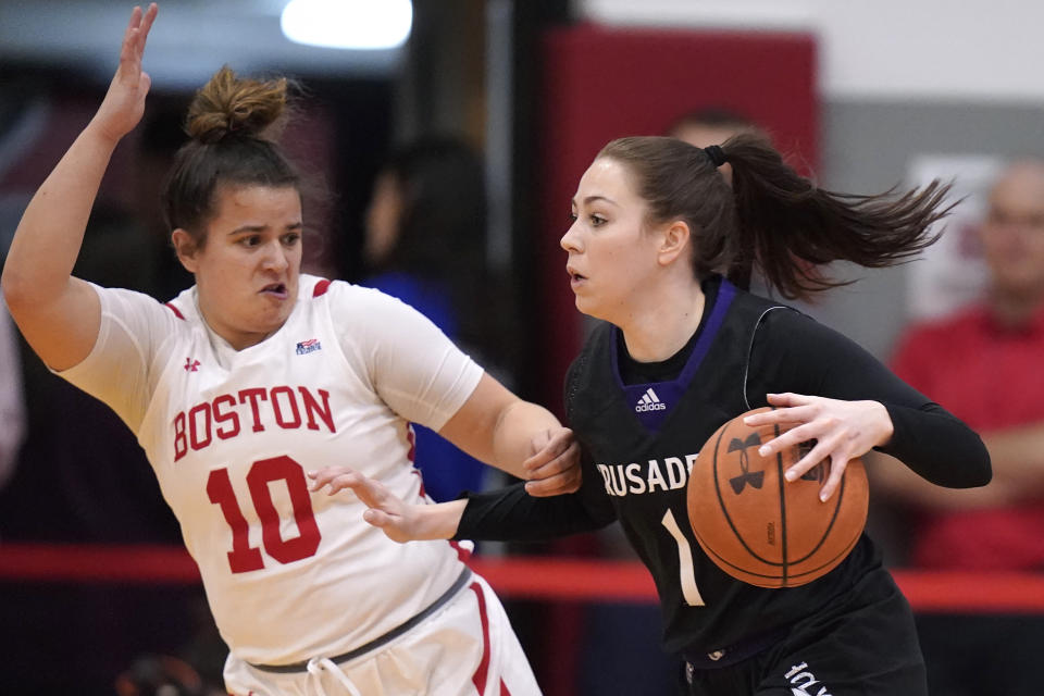 Holy Cross guard Addisyn Cross (1) drives toward the basket as Boston University guard Alex Giannaros (10) defends in the first half of an NCAA women's Patriot League college basketball championship game, Sunday, March 12, 2023, in Boston. (AP Photo/Steven Senne)