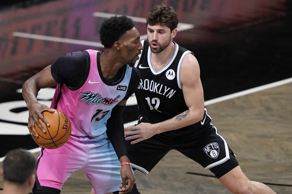 Brooklyn Nets' Joe Harris (12) defends against Miami Heat's Bam Adebayo (13) during the second half of an NBA basketball game Saturday, Jan. 23, 2021, in New York. (AP Photo/Frank Franklin II)