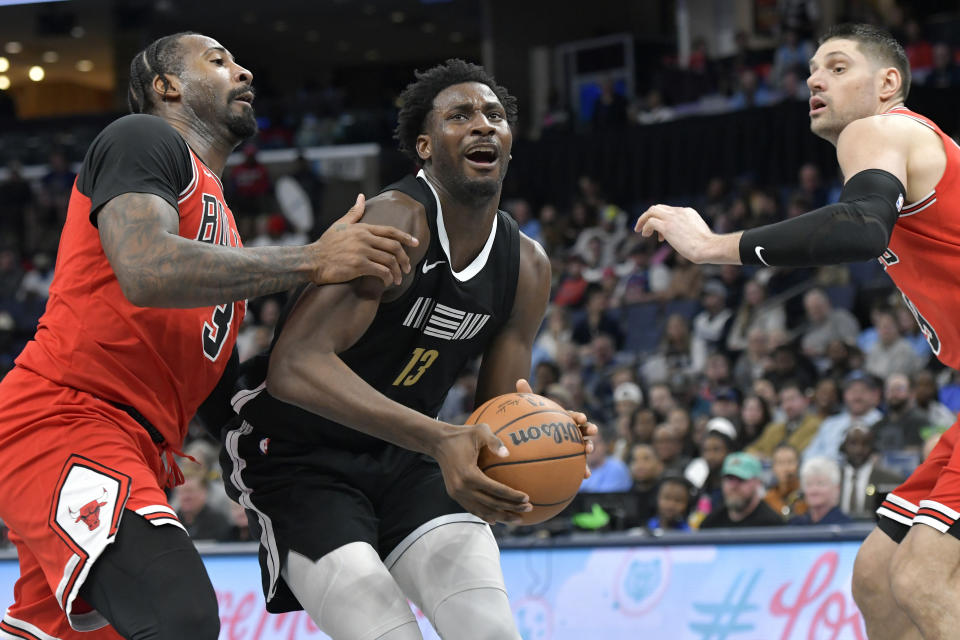 Memphis Grizzlies forward Jaren Jackson Jr. (13) looks to the basket from between Chicago Bulls center Andre Drummond (3) and center Nikola Vucevic during the second half of an NBA basketball game Thursday, Feb. 8, 2024, in Memphis, Tenn. (AP Photo/Brandon Dill)