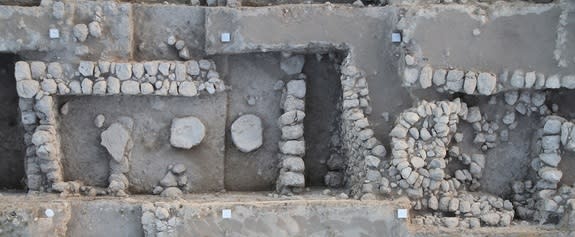 Bird's-eye view over the sacred complex, with round stone structure at right and temple at left.