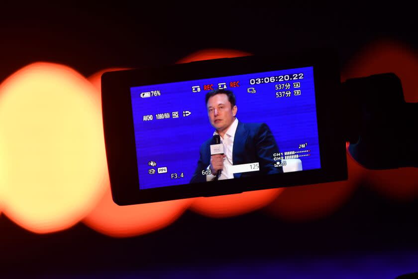 Elon Musk (R), Co-founder and CEO of Tesla, is seen on the screen of a video camera during the World Artificial Intelligence Conference (WAIC) in Shanghai on August 29, 2019. (Photo by HECTOR RETAMAL / AFP) (Photo credit should read HECTOR RETAMAL/AFP/Getty Images)