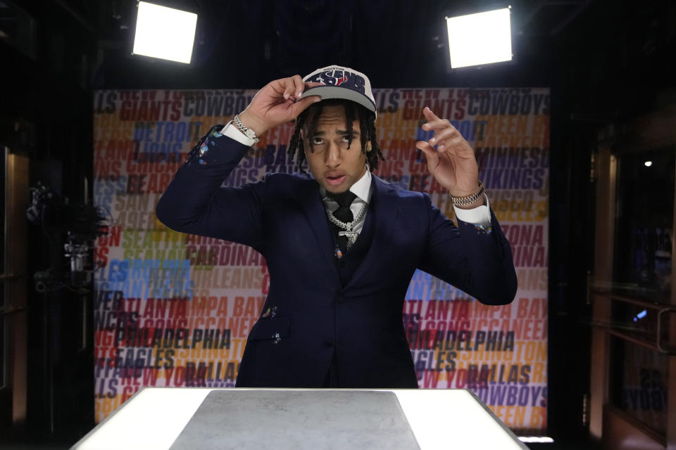 Ohio State quarterback C.J. Stroud puts on a hat after being chosen by the Houston Texans with the second overall pick during the first round of the NFL football draft, Thursday, April 27, 2023, in Kansas City, Mo. (AP Photo/John Locher)