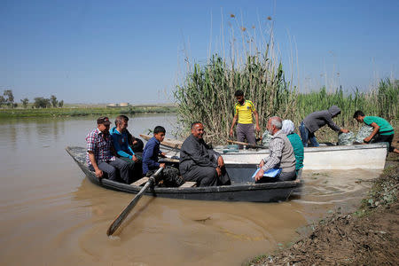 Displaced Iraqis from Mosul cross the Tigris by boat as flooding after days of rainfall has closed the city's bridges, at the village of Thibaniya, south of Mosul, Iraq April 16, 2017. REUTERS/Muhammad Hamed