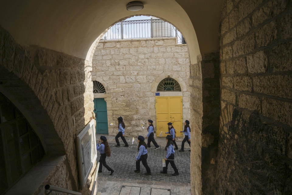 Girls scouts march during Christmas parade towards the Church of the Nativity, traditionally believed to be the birthplace of Jesus Christ, in the West Bank town of Bethlehem, Saturday , Dec. 24, 2022. (AP Photo/Mahmoud Illean)