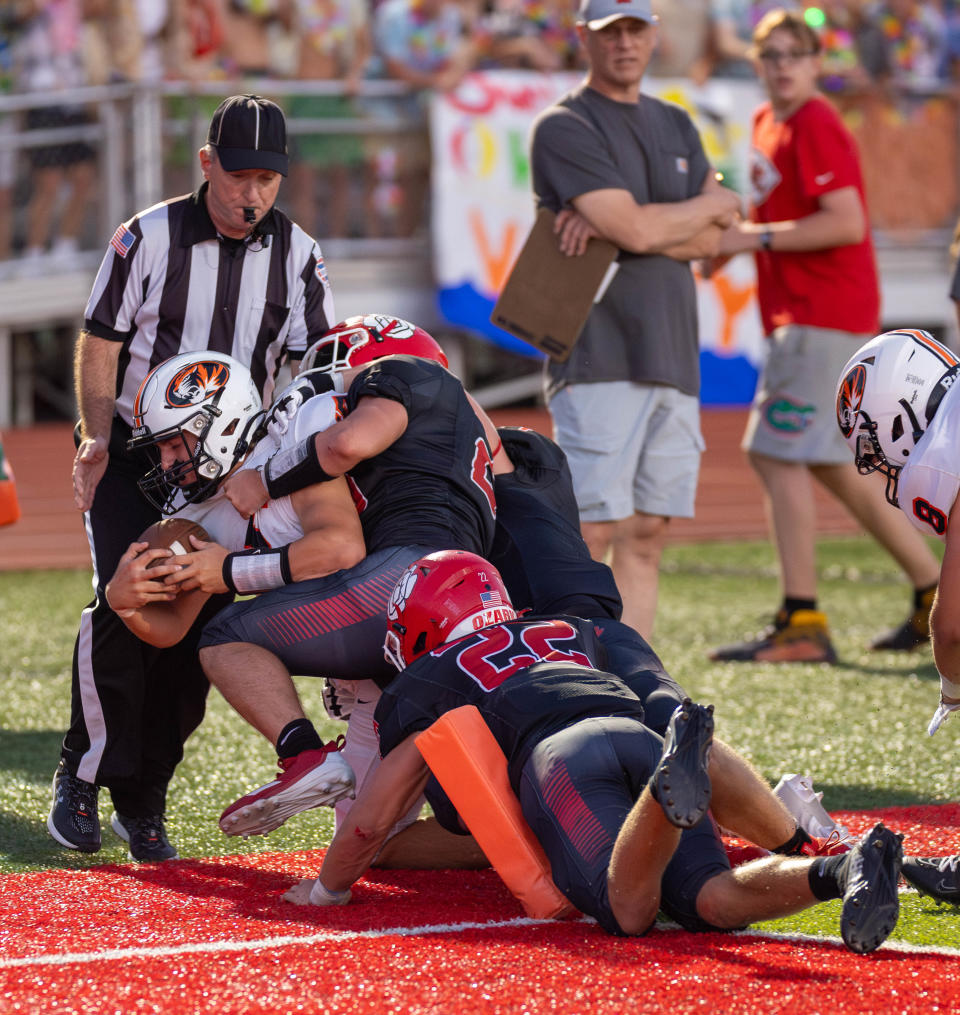 Republic QB Wyatt Woods is tackled just before reaching the pylons by Ozark’s Peyton Bullinger (22), and Charles Lawson on August 31, 2023.