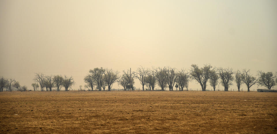 Smoke and dust sweep across a field near Las Vegas, N.M., on Wednesday, May 4, 2022. A fire in the area has torched 250 square miles (647 square kilometers) over the last several weeks. (AP Photo/Thomas Peipert)