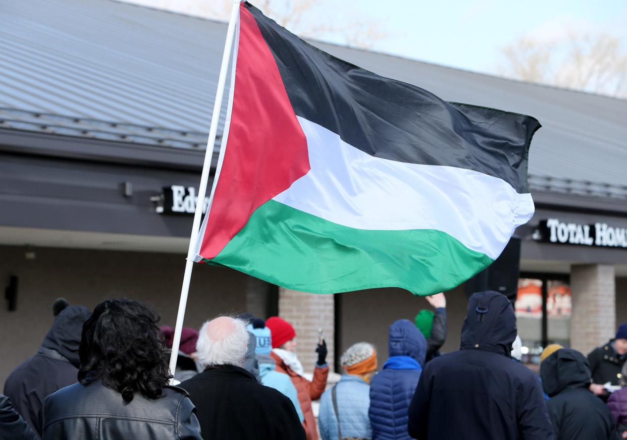 A person carries a flag of Palestine Wednesday, March 27, 2024, outside the offices of Indiana U.S. Rep. Rudy Yakym, R-2nd, at a prayer vigil for peace by the group Mennonite Action calling on the Congressman to work for a ceasefire in Gaza.