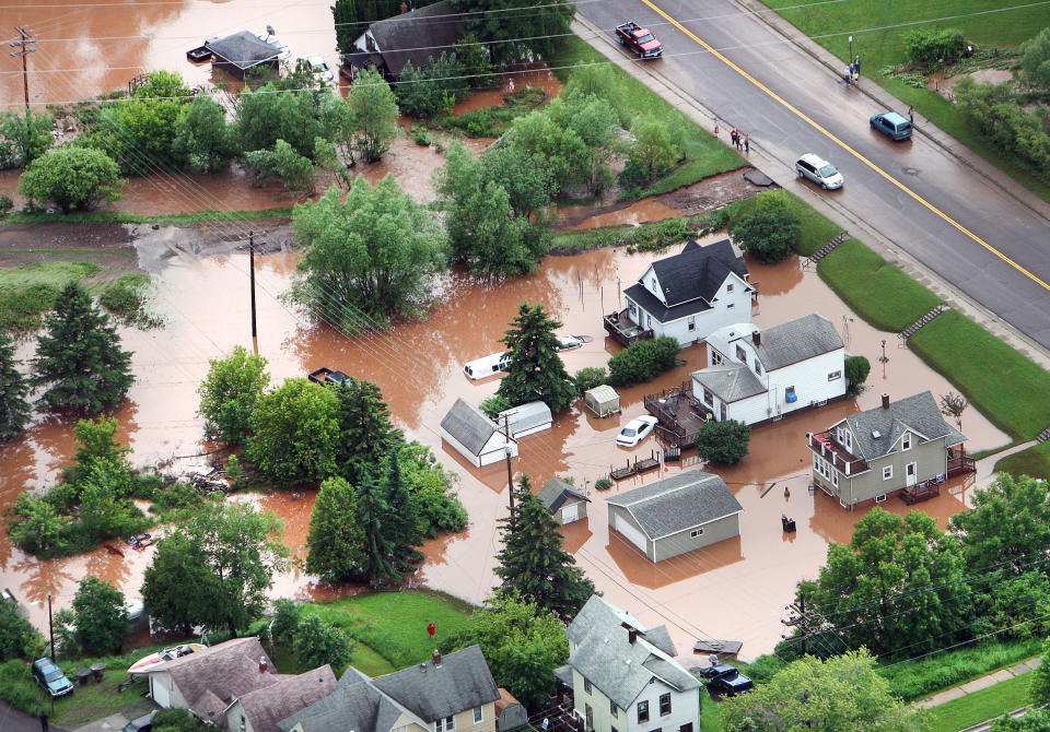 In this aerial photo, waters from an overflowing nearby creek inundate homes in the Irving Park neighborhood of Duluth, Minn., Wednesday afternoon, June 20, 2012. Residents evacuated their homes and animals escaped from pens at a zoo as floods fed by a steady torrential downpour struck northeastern Minnesota, inundating the city of Duluth, officials said Wednesday. (AP Photo/The Duluth News-Tribune, Bob King)