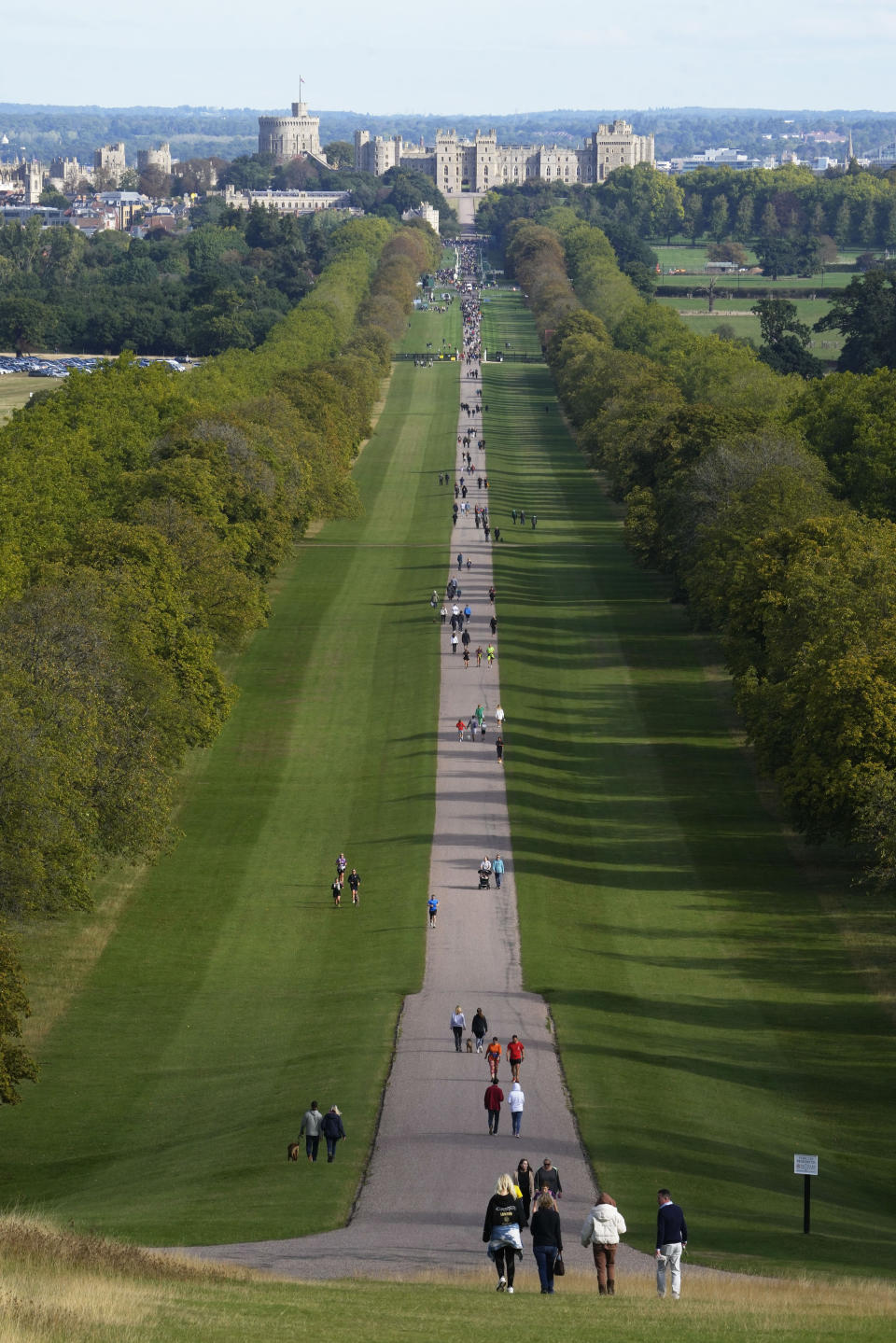 People make their way along the Long Walk towards Cambridge gate outside Windsor Castle to lay flowers for the late Queen Elizabeth II in Windsor, England, Sunday, Sept. 18, 2022. The Queen will lie in state in Westminster Hall for four full days before her funeral on Monday Sept. 19. (AP Photo/Gregorio Borgia)