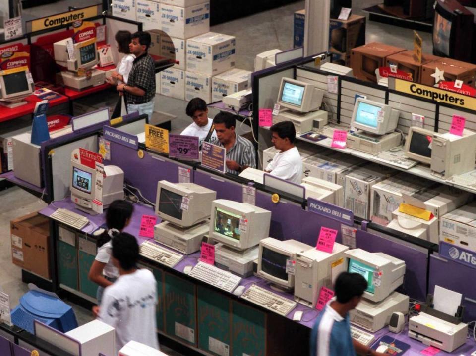 Customerslook at computers at Incredible Universe store near Miami International Airport in 1995.