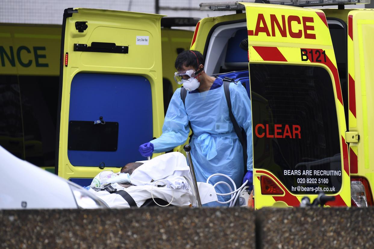 A patient is taken from an ambulance outside St Thomas Hospital in London, Wednesday, April 1, 2020, the hospital is one of many treating Coronavirus patients.