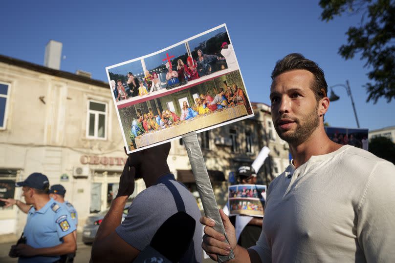 El boxeador Tristan Tate exhibe como protesta una pancarta de la ceremonia de apertura que evocaría la obra de Da Vinci 'La última cena'