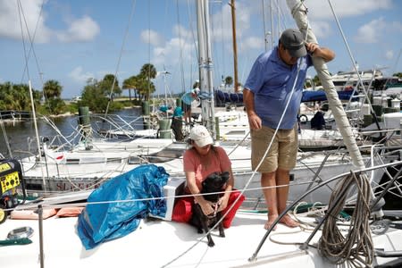 Lisa and Ned Keahey, who live in a sailboat and plan to stay aboard during Hurricane Dorian, are seen with their dog Princess Leia at a marina in Titusville