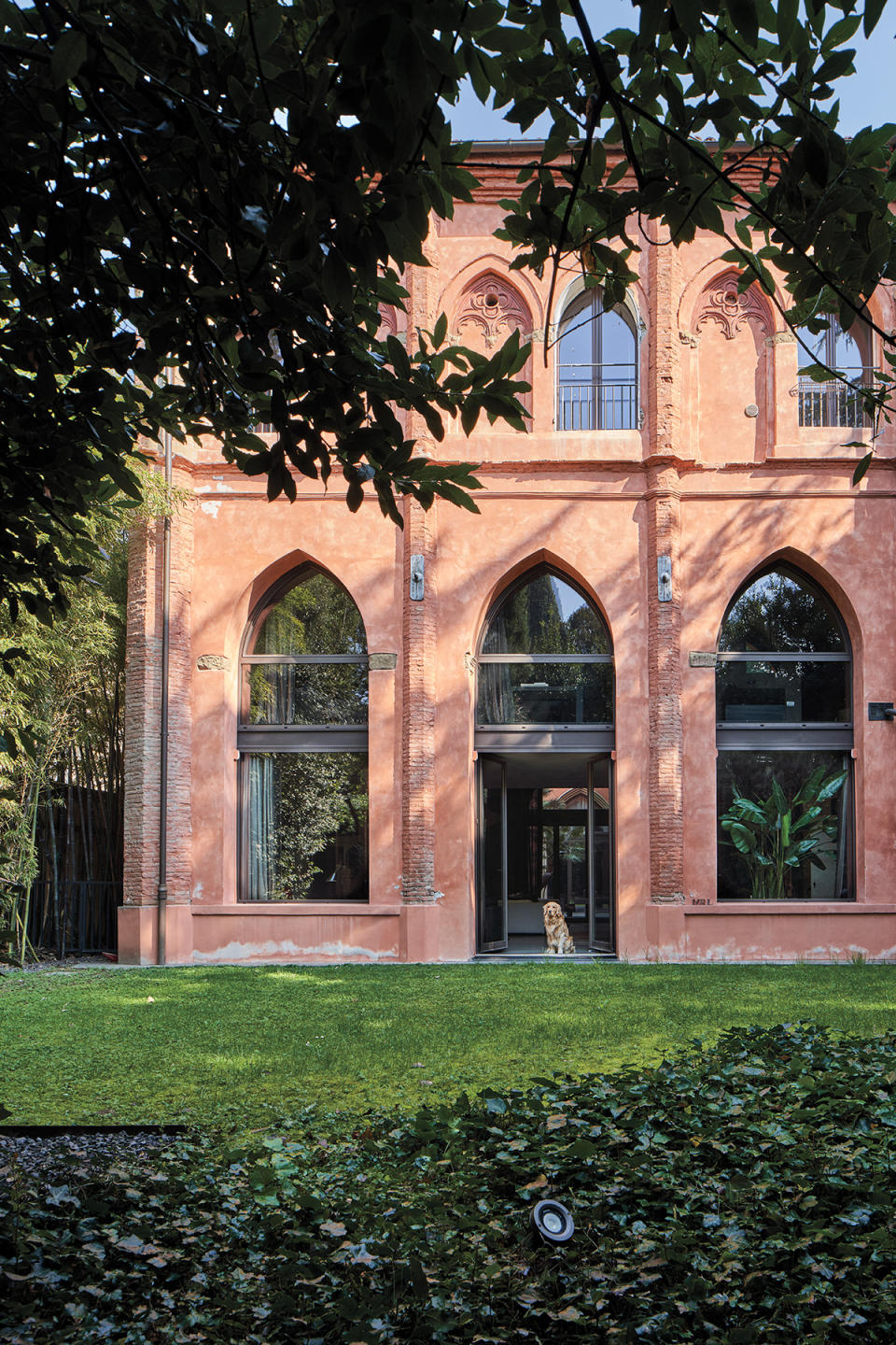 Gothic arches—seen on the exterior and below, in the ground floor’s dramatic corridor—reveal the home’s ecclesiastical origin.