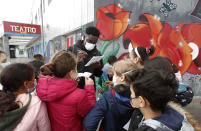 Actor Giuseppe Dave Seke signs autographs to children, in Milan, Italy, Tuesday, April 27, 2021. The Netflix series “Zero,” which premiered globally last month, is the first Italian TV production to feature a predominantly black cast, a bright spot in an otherwise bleak television landscape where the persistent use of racist language and imagery in Italy is sparking new protests. (AP Photo/Antonio Calanni)