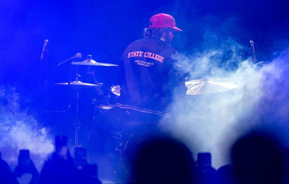 Wearing a jacket that says "State College," Thomas Rhett rises from the stage playing the drums to open his performance at the Bryce Jordan Center on Friday.