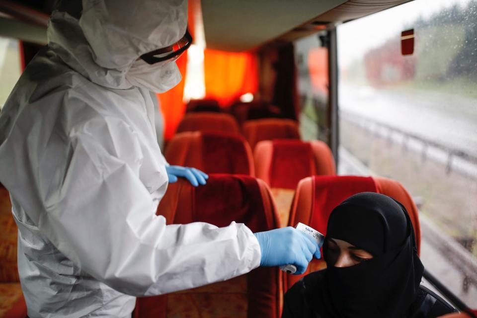 A health official measures the body temperature of a passenger on a bus at a check point in Istanbul, on March 29.