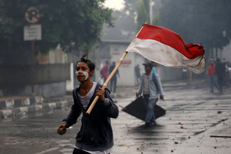 A protester carries Indonesia's national flag during a protest following the announcement of last month's election official results in Jakarta, Indonesia, May 22, 2019. REUTERS/Willy Kurniawan