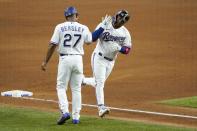 Texas Rangers third base coach Tony Beasley (27) celebrates with Willie Calhoun, right, as he runs home after hitting a solo home run off of New York Yankees starting pitcher Gerrit Cole in the fifth inning of a baseball game in Arlington, Texas, Monday, May 17, 2021. (AP Photo/Tony Gutierrez)