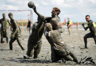 <p>Participants fight for the ball during a handball match at the so called “Wattoluempiade” (Mud Olympics) in Brunsbuettel at the North Sea, Germany July 30, 2016. (REUTERS/Fabian Bimmer) </p>