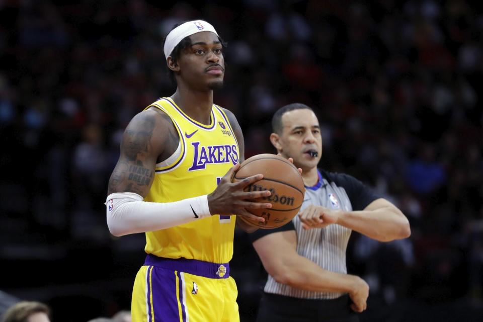 Lakers forward Jarred Vanderbilt holds the ball during a game.