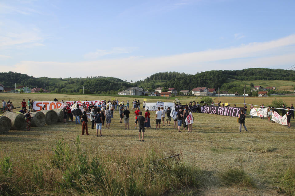 People take part in a protest against the violent pushbacks of migrants, allegedly conducted by Croatian police, near the border crossing between Croatia and Bosnia Herzegovina in Maljevac, Croatia, Saturday, June 19, 2021. More than one hundred members of human rights NGO's, mostly from Italy, but also from Germany, Austria, Spain and Slovenia blocked the border traffic for about two hours protesting demanding a stop of all deportation of migrants, and cancellation of EU's Frontex operations at borders, preventing migrants from traveling. (AP Photo/Edo Zulic)