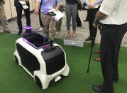 In this Thursday, July 18, 2019, photo, a "field support robot" is demonstrated before the media at Toyota Motor Corp. headquarters in Tokyo. The Japanese automaker Toyota, a major Olympic sponsor, is readying various robots for next year’s Tokyo Olympics, including the one which has intelligence to avoid obstacles in its path and helps bring back thrown objects like javelins and discuses. (AP Photo/Yuri Kageyama)