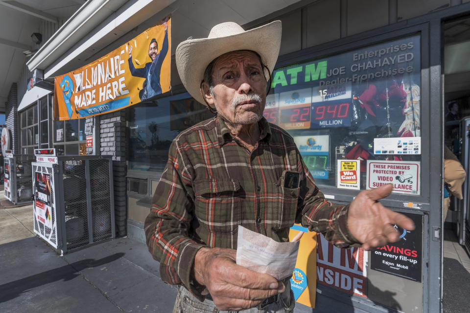 Roberto Ramirez, 77, from Guadalajara, Mexico holds a SuperLotto Plus ticket at the gas station that previously sold the $2.04 billion-winning Powerball ticket award at Joe's Service Center, a Mobil gas station at Woodbury Road and Fair Oaks Avenue in Altadena, Calif., Friday, Jan. 6, 2023. Lottery players whose numbers didn't hit or who forgot to even buy a ticket will have another shot at a nearly $1 billion Mega Millions prize. The estimated $940 million jackpot up for grabs Friday night has been growing for more than two months and now ranks as the sixth-largest in U.S history. (AP Photo/Damian Dovarganes)