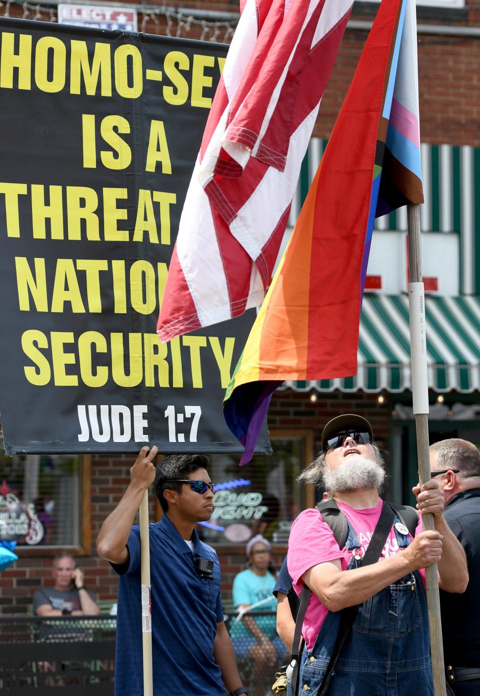 Tony Collins-Sibley of Alliance plants his flags strategically in front of protesters to block their message Saturday as speakers take the stage at the Stark Pride Festival in Canton.