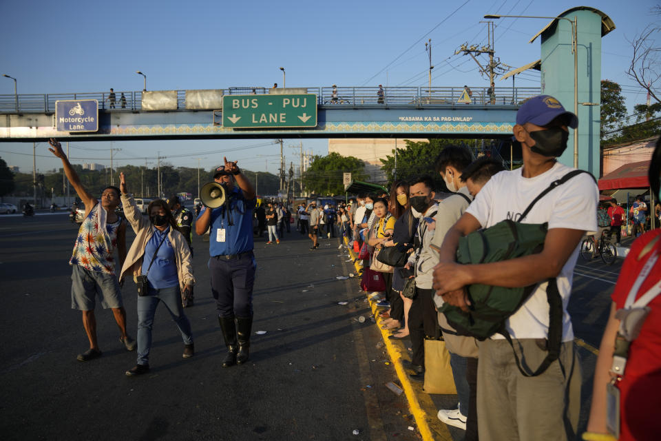 Commuters wait for a ride during a passenger jeepney strike in Quezon city, Philippines on Monday, March 6, 2023. Philippine transport groups launched a nationwide strike Monday to protest a government program drivers fear would phase out traditional jeepneys, which have become a cultural icon, and other aging public transport vehicles. (AP Photo/Aaron Favila)