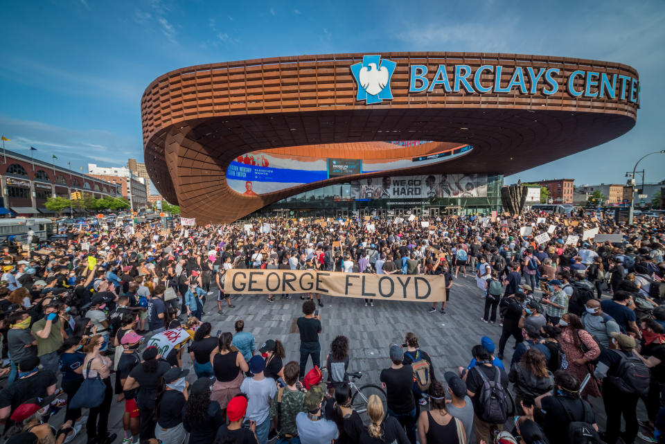 Protesters holding a giant banner reading GEORGE FLOYD outside the Barclays Center. Hundreds of protesters made their way toward Barclays Center in Brooklyn to demonstrate against police brutality in the wake of George Floyd's death while in police custody in Minneapolis. (Erik McGregor/LightRocket via Getty Images)