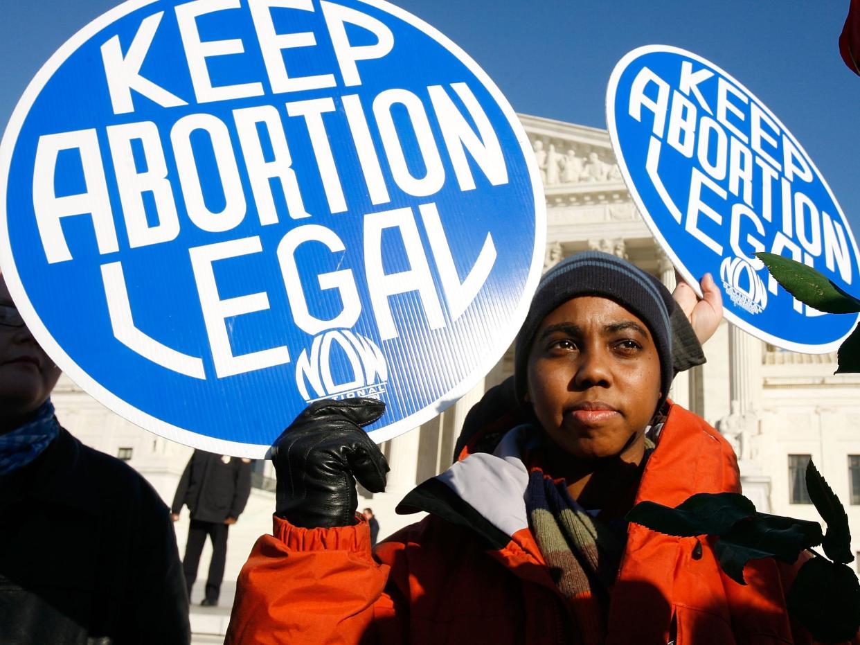 Local pro-choice activist Lisa King holds a sign in front of the U.S. Supreme Court in 2009