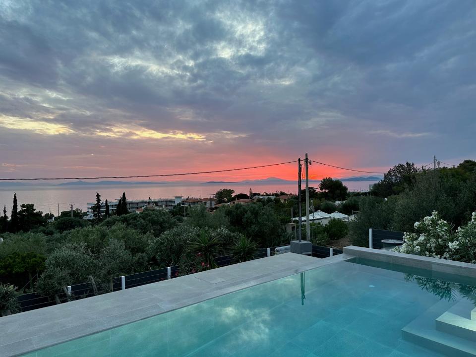 Sunset in Athens over treetops and pools