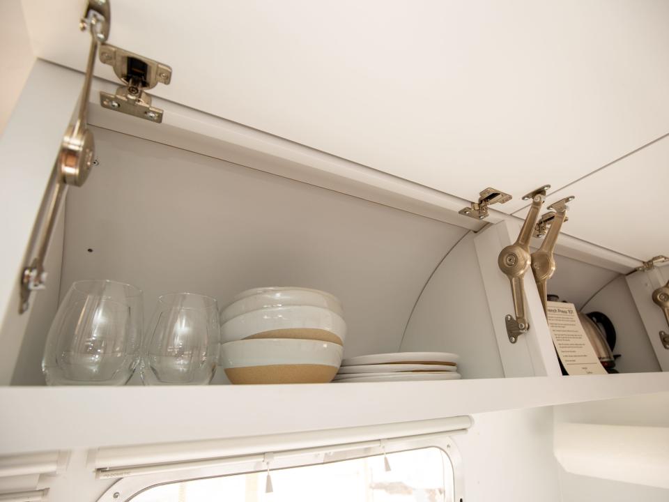 Autocamp Joshua Tree's Airsteram trailer with bowls, plates, glasses inside a cabinet