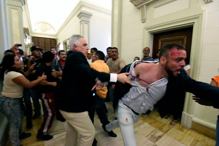 An opposition deputy struggles while pro-government supporters force their way to the National Assembly during an extraoridinary session called by opposition leaders, in Caracas on October 23, 2016