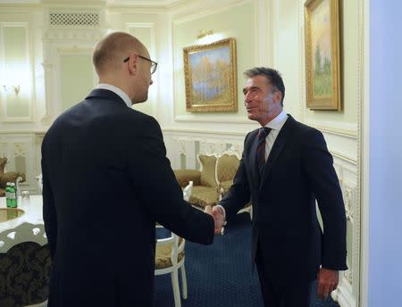 Ukraine's Prime Minister Arseny Yatseniuk (L) greets NATO Secretary General Anders Fogh Rasmussen during their meeting in Kiev August 7, 2014. REUTERS/Andrew Kravchenko/Pool